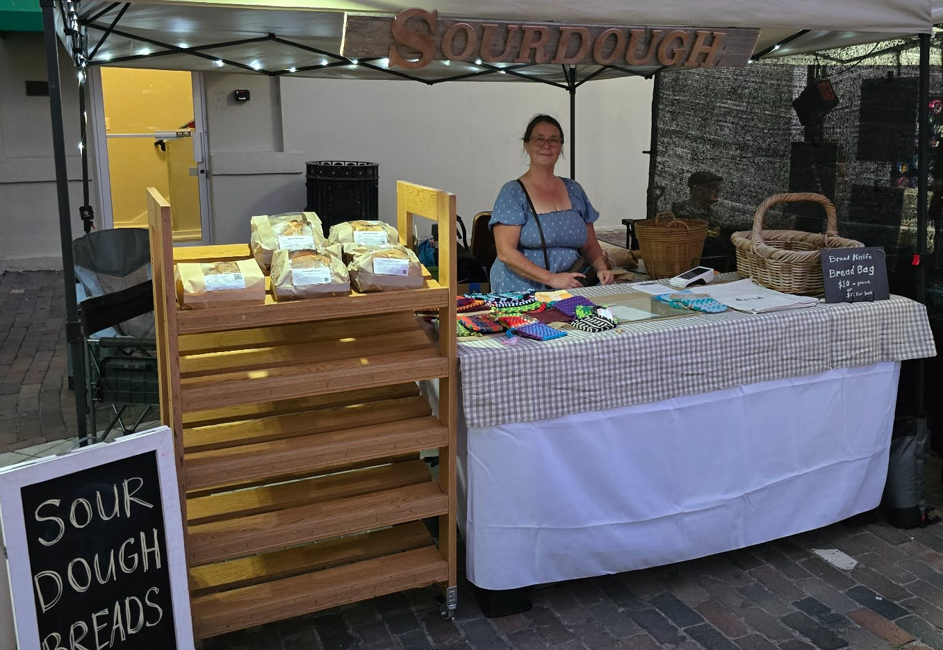 Michelle at her farmers market booth with fresh sourdough bread